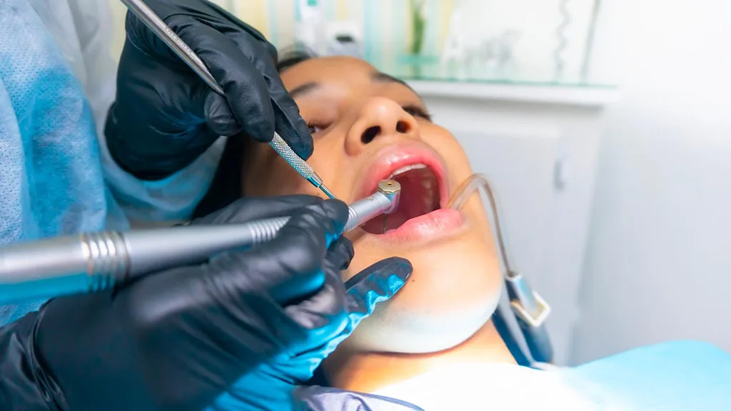dentist examining the patient's teeth with dental instruments