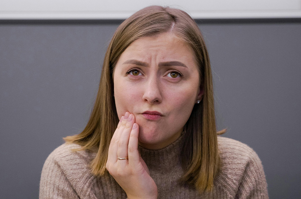 Woman sitting with a thoughtful expression, showing signs of anxiety